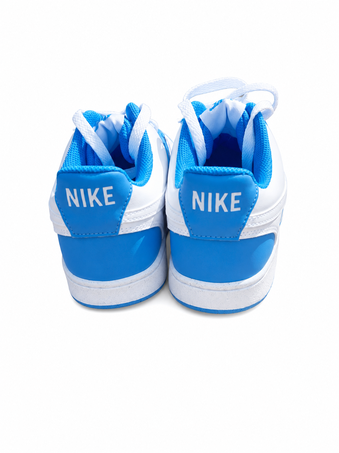 A pair of Nike low-top sneakers shown from the back, featuring a white leather upper with bright blue overlays, white laces, and the white 'NIKE' logo printed on the blue heel tabs.